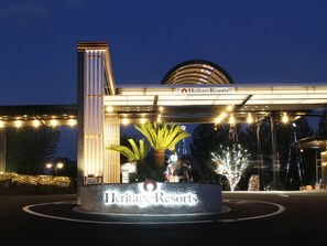 Entrada de un hotel con un letrero que dice "Heritage Resorts" y un camino de acceso circular.