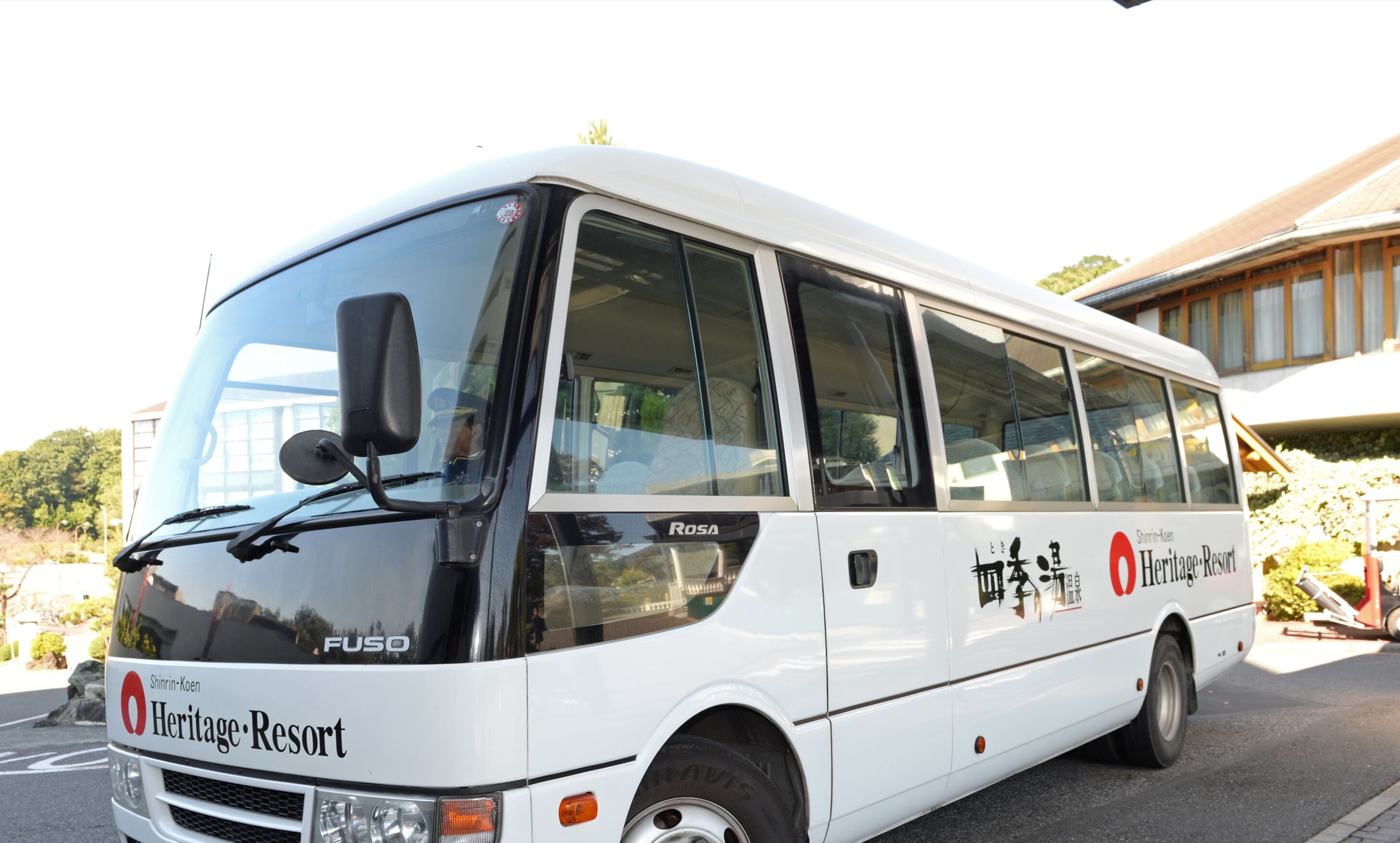 Un autobus blanc arborant la marque « Heritage Resort » et le modèle « FUSO ».