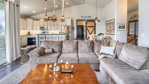 A spacious living room with a large sectional sofa, a wooden coffee table, and a kitchen in the background. - Perfect Lake and Mountain Views! (Monument)