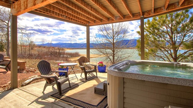 A covered patio with a hot tub, outdoor seating, and a scenic mountain view. - Perfect Lake and Mountain Views! (Monument)