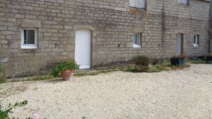 A stone building with multiple windows and a gravel driveway.