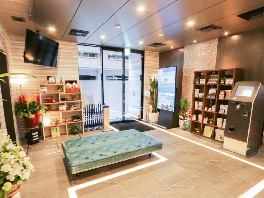 Una hall d'albergo con una reception, un'area relax e l'esposizione dei servizi offerti.