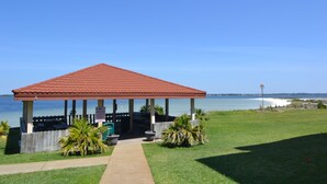 A gazebo with a red roof, a concrete pathway leading to it, and a view of the ocean. - "Julie's Jewel"  - A Real Gem - Perfect for A Couple! (Navarre)