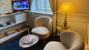 A hotel room with a comfortable seating area, a television, and a window with curtains. - Apartment/ flat - Strasbourg (Strasbourg)