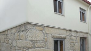 Un edificio a due piani con facciata in pietra e tetto piatto.