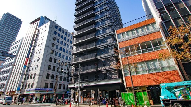 A modern hotel building with multiple floors, a prominent sign for 'Hotel Livenax', and a visible entrance. - Hotel Livemax Shinsaibashi East (Osaka)