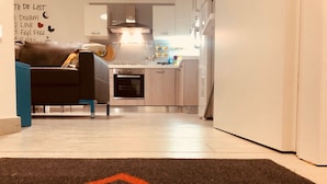 Een moderne keuken met witte kasten, een oven van roestvrij staal en een magnetron.