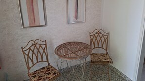 A corner room with two wooden chairs, a small round table, and two framed artworks on the wall. - Apartment Srsen for 2 people in Kuciste (Kucište)