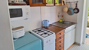 A compact kitchen with a gas stove, a microwave, a coffee maker, and a sink. - Apartment Srsen for 2 people in Kuciste (Kucište)