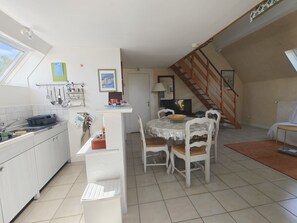 A kitchen with a dining area, a staircase, and a TV.