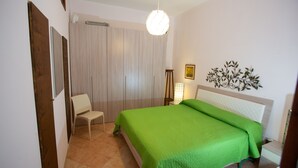Une chambre à coucher comprenant un lit, une chaise, une table de chevet et un élément décoratif fixé au mur.