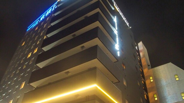 Un hôtel à plusieurs étages, doté d’une enseigne lumineuse et d’une architecture moderne.