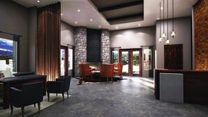A modern interior with a stone fireplace, a dining area with red chairs, and a large window offering a view of the outdoors. - Gorgeous views of the rural surroundings! (Marble Falls)