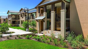 A residential building with multiple balconies, a covered entryway, and a landscaped garden. - Gorgeous views of the rural surroundings! (Marble Falls)