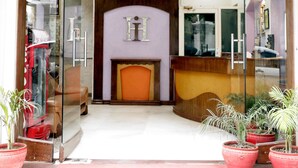 The entrance of Hotel Heritage Inn with a reception desk, a clock, and a fireplace. - Hotel Heritage Inn (Amritsar)