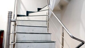 A spiral staircase with metal railings and a light fixture at the top. - Hotel Heritage Inn (Amritsar)