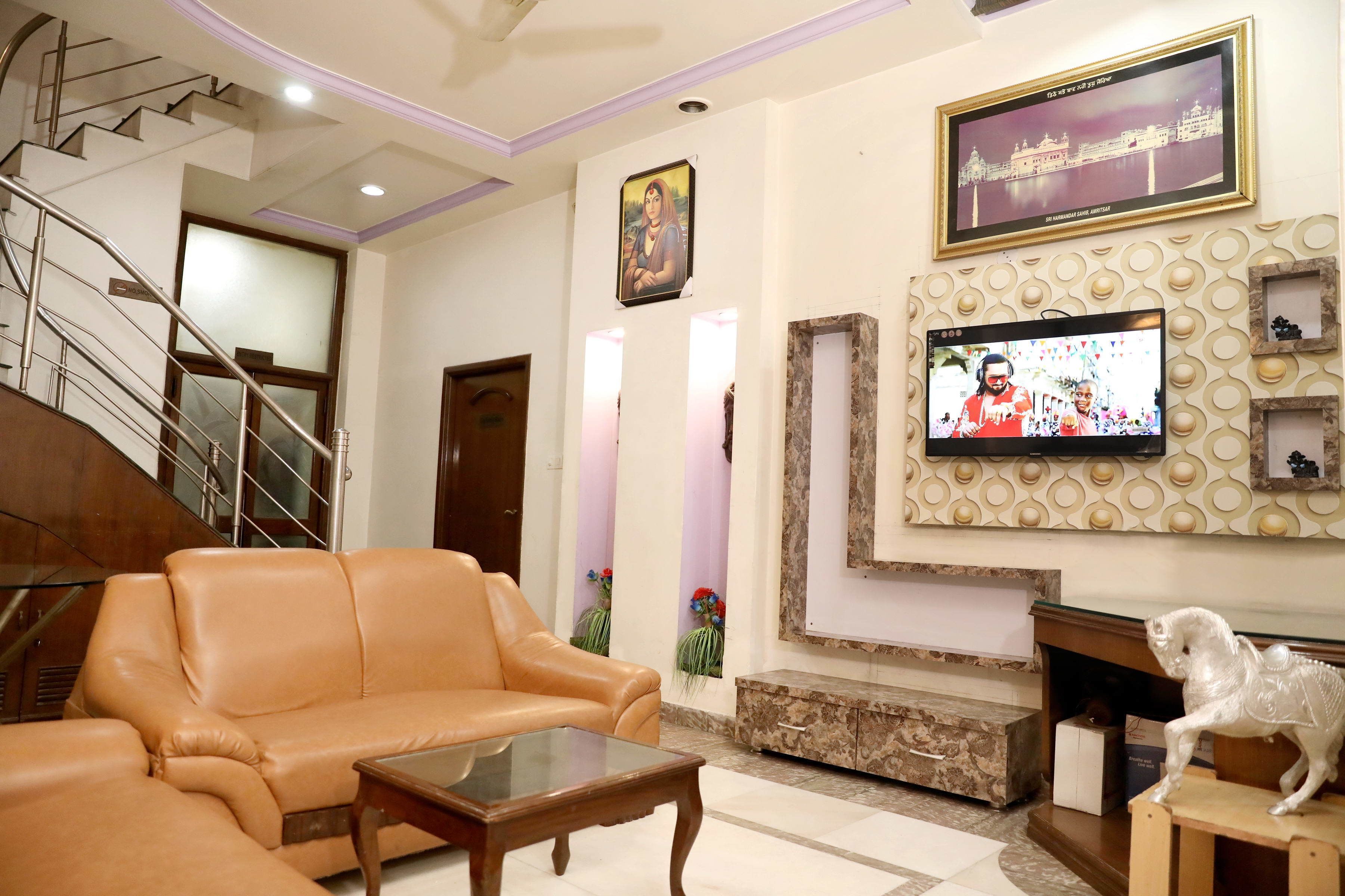 A living room with a sofa, a coffee table, a television, and a fireplace.