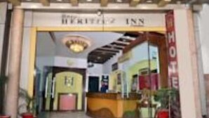 A hotel entrance with a large glass facade, a sign reading "HOTEL", and a reception desk. - Hotel Heritage Inn (Amritsar)