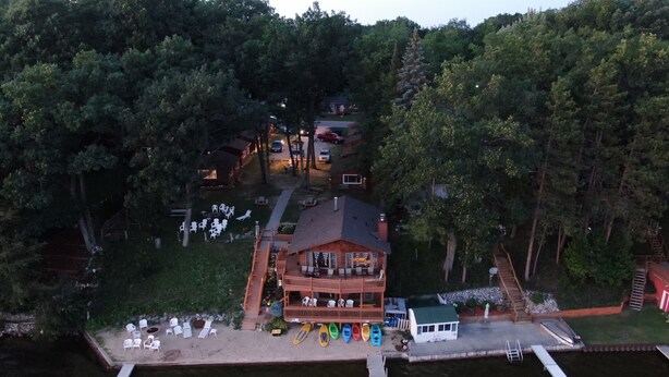 An aerial view of a lodge with a dock, surrounded by dense forest. - Lake Cabin Resort - Cabin 1       (Fife Lake)