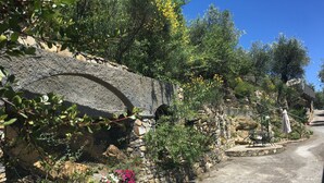 A stone wall with flowers and a clear sky.