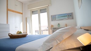 Een slaapkamer met een bed, een mand vol bloemen en uitzicht op het omliggende landschap.