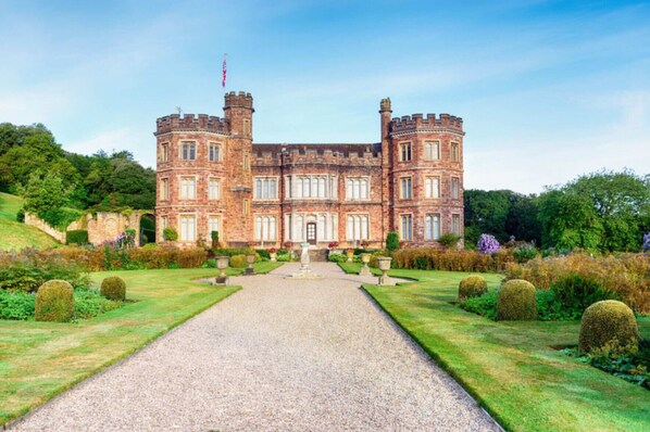 A large, historic building with a symmetrical facade, a central entrance, and a formal garden with hedges and topiary. - Eventide - Three Bedroom Cottage, Sleeps 5 (Kingsand)