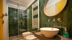 A modern bathroom with a glass-enclosed shower, a white sink, and a large mirror. - Modern, cosy Garden Suite, parking u.r. (Roma)