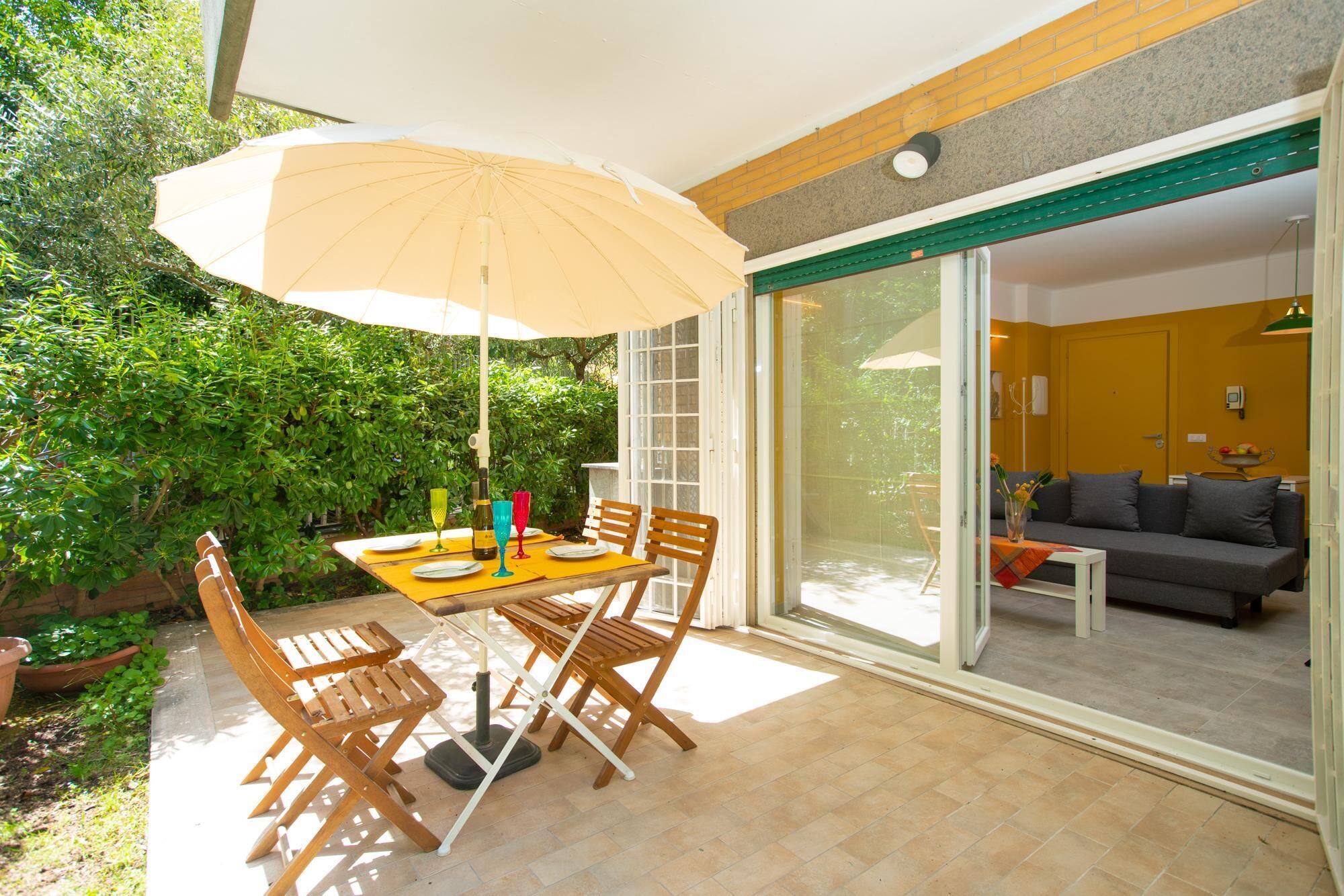 A patio with a table, chairs, and an umbrella.