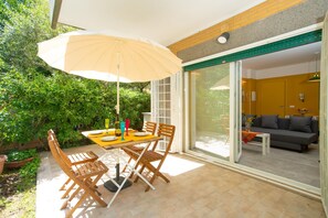 A patio with a table, chairs, and an umbrella. - Modern, cosy Garden Suite, parking u.r. (Roma)