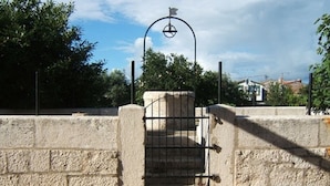 Eine Steinmauer mit einem Metalltor und einem Metallbogen.