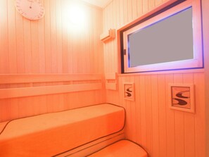 Un sauna avec des murs et des bancs en bois.
