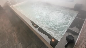 A hot tub with a tiled floor and a window above it. - HOTEL LiVEMAX PREMIUM Himejieki-Minami (Himeji)