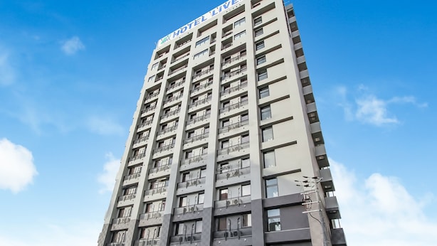 A tall hotel building with balconies and a clear sky. - HOTEL LiVEMAX PREMIUM Himejieki-Minami (Himeji)