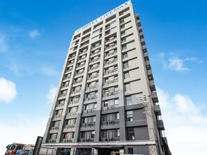 Um edifício de hotel alto, com varandas e céu claro.