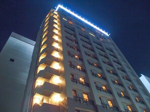 Un hôtel à plusieurs étages, doté de balcons illuminés et d’une architecture moderne.