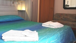 Ein Schlafzimmer mit einem Bett, einem Holzschrank, einem Spiegel und einer Tür.