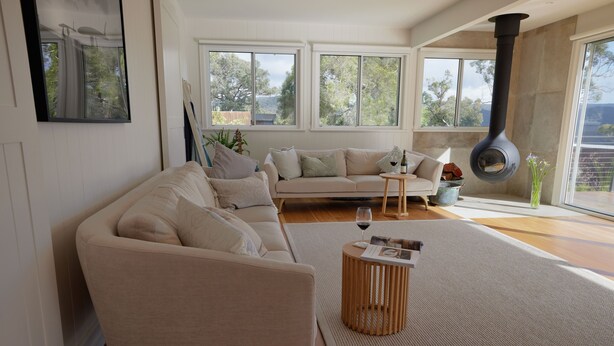 A modern living room with a sofa, a coffee table, and a fireplace.