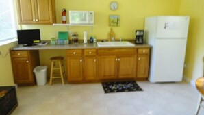 Una cocina compacta con armarios de madera, microondas, lavaplatos y refrigerador.