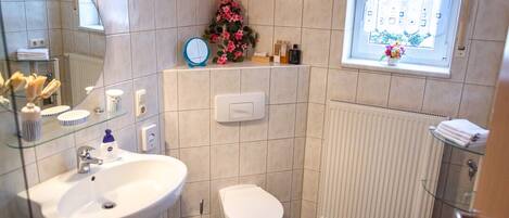 A bathroom with a sink, toilet, and a window with a view.