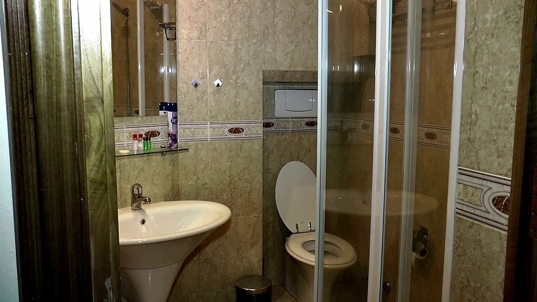 A bathroom with a sink, toilet, and shower.