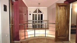 Uma escadaria com guarda-corpo de vidro que leva a um segundo andar.