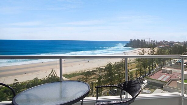 Un balcon avec vue sur la plage et l’océan.
