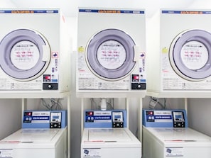 Three identical machines with control panels and a label in a foreign language. - HOTEL LiVEMAX  Nagoya Taikodori-Guchi (Nagoya)