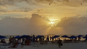 A beach with people and umbrellas, a sunset, and a ship in the distance. - Yikal house. Beautiful house 4 rooms (10 pers), 4 tennis court pools. (38)