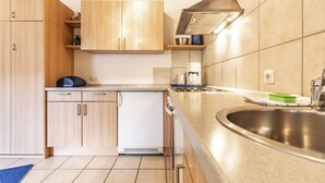 Een moderne keuken met houten kastjes, een roestvrijstalen spoelbak en een inbouwvaatwasser.