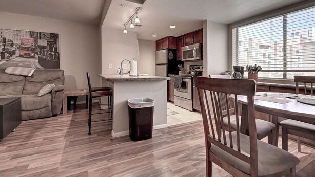 A modern kitchen with a central island, wooden dining table, and chairs. - See the Valley of the Sun, Arizona State University and Tempe just a short walk. (Tempe)