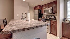 A kitchen with granite countertops, wooden cabinets, stainless steel appliances, and recessed lighting. - See the Valley of the Sun, Arizona State University and Tempe just a short walk. (Tempe)