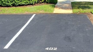 Un estacionamiento con una línea blanca y el número '402' pintado sobre el pavimento.