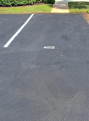 A parking lot with a white line and the number '402' painted on the asphalt.