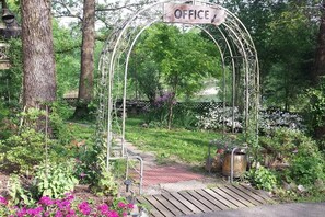 Stroll through the serene garden, featuring a tranquil archway entrance and lush greenery.